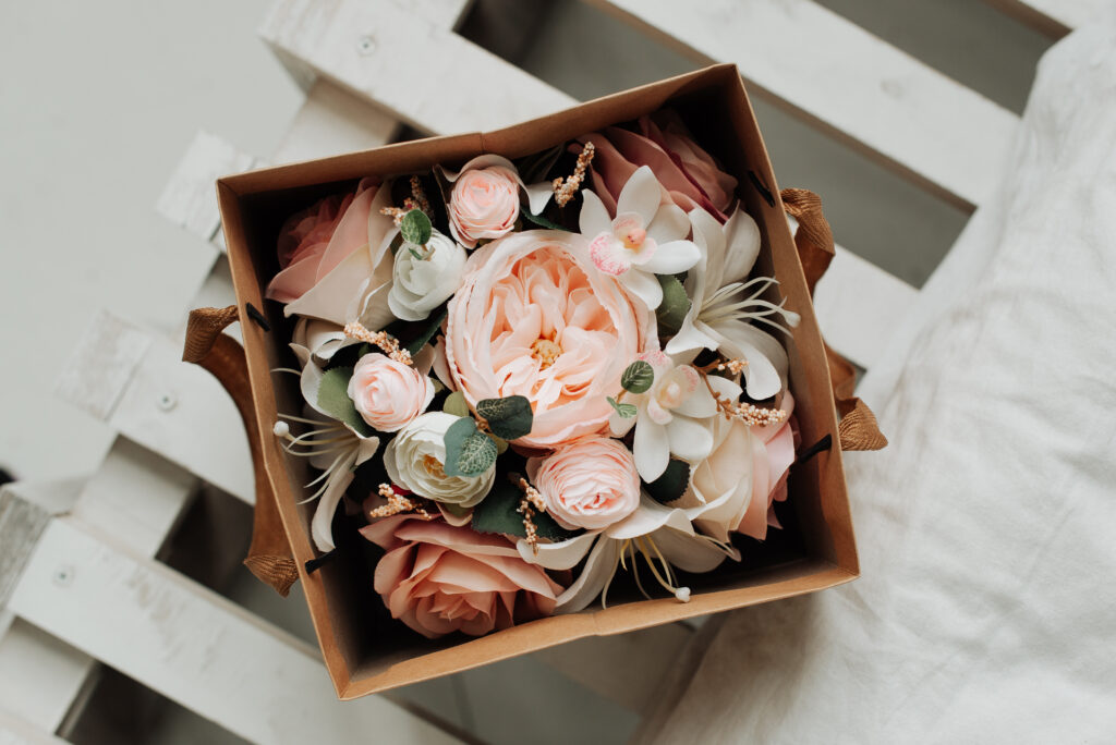 Decorative flowers in a paper box on a table close-up