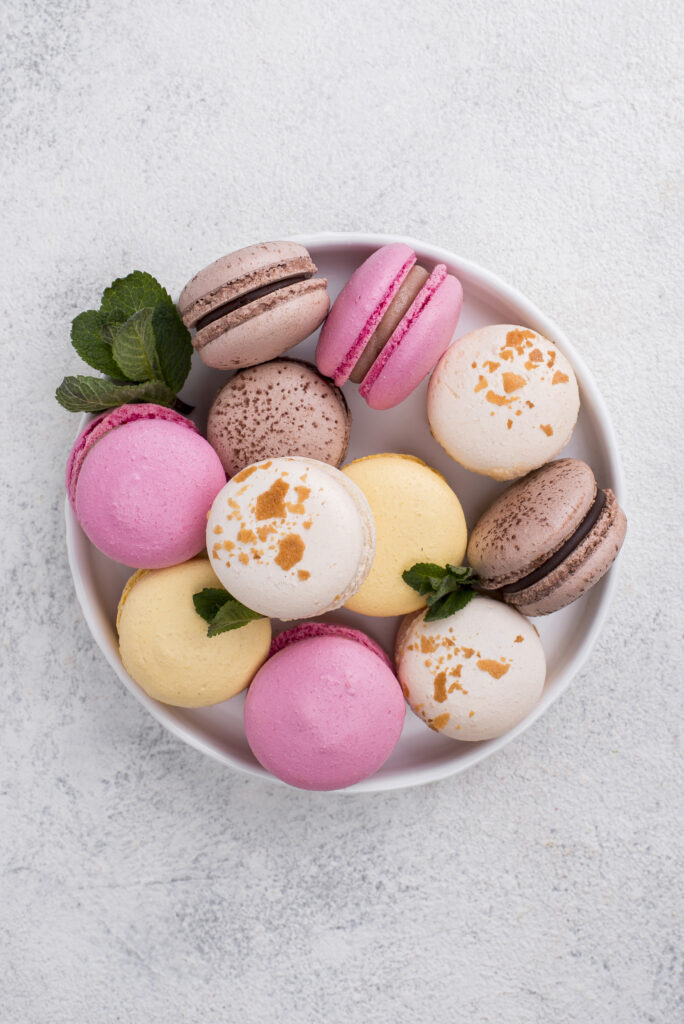 top view colored macarons in a round shape custom macaron box with colored on a white background
